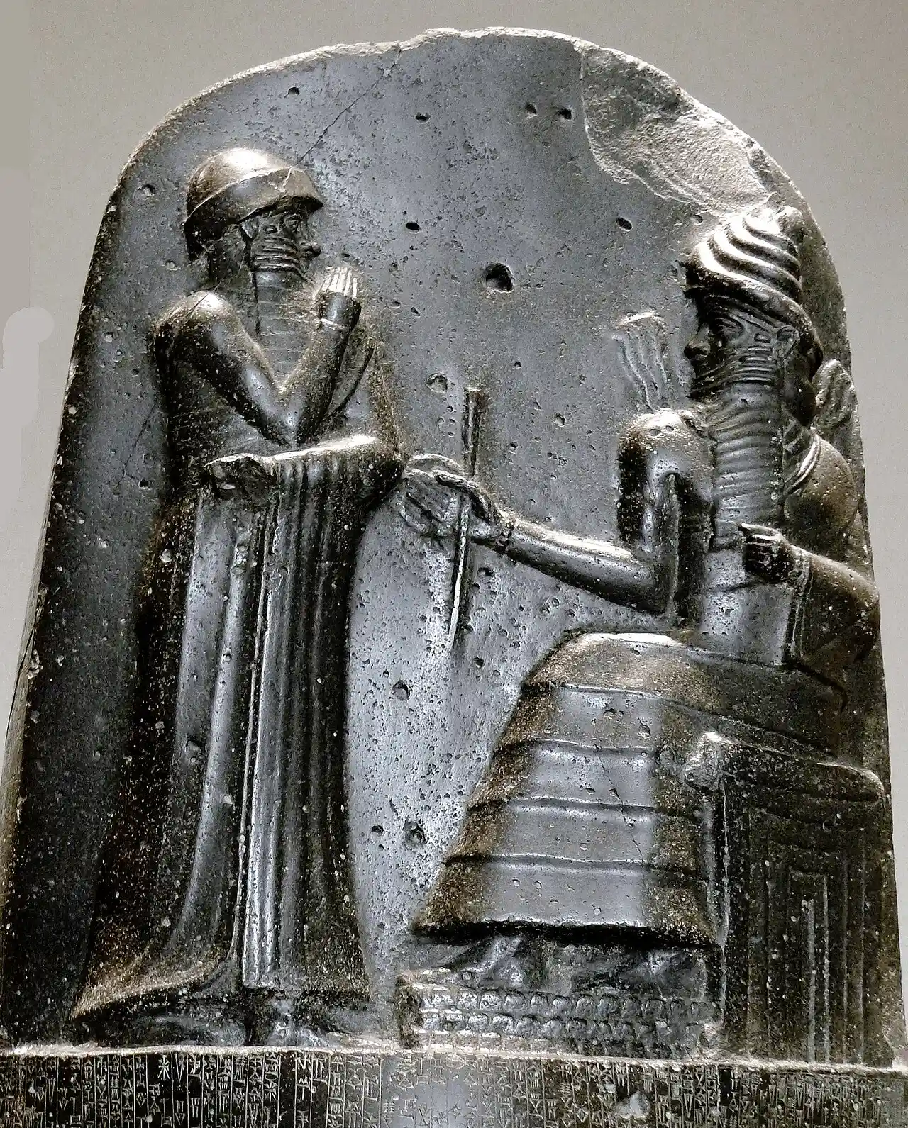 Relief at the top of Hammurabi’s law stele, showing a standing ruler facing a seated deity.