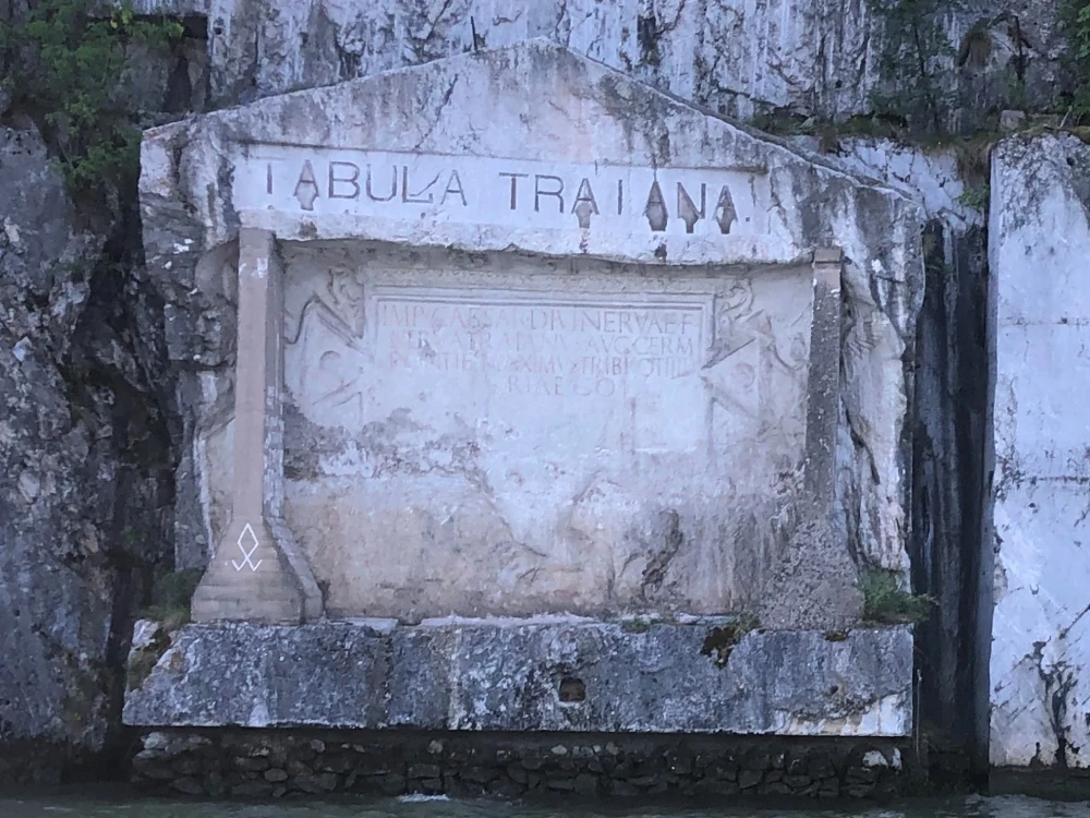 A weathered Latin inscription set into a rock face beneath the large lettering Tabula Traiana.